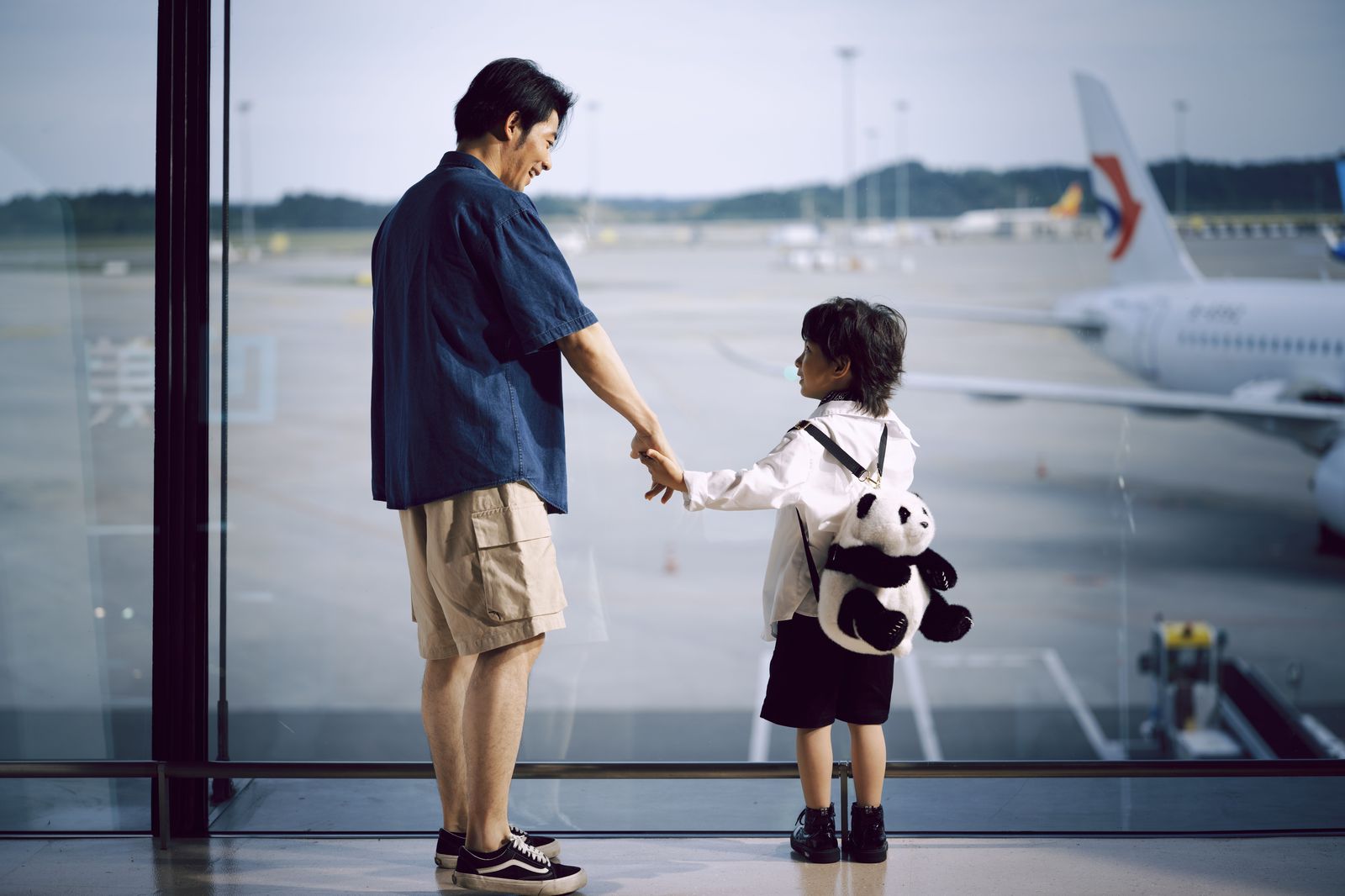 A family arriving with luggage and a child seat, the situation where a waiting car matters most